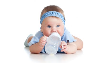 תינוקת שותה בקבוק חלב